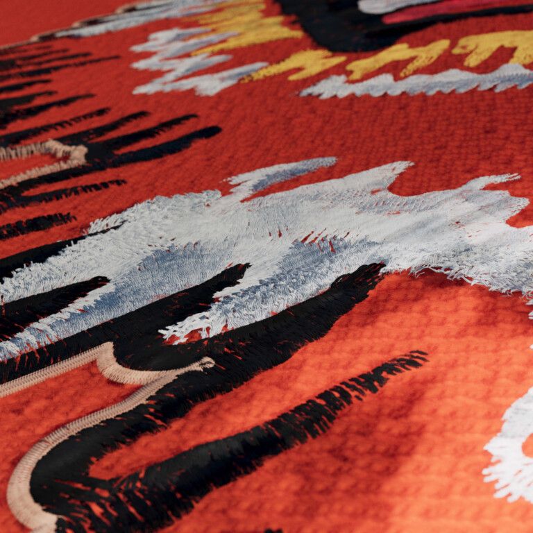 Close-up of orange knit with a frayed white stitched shape over black stitched strokes and a beige corded outline, yellow and white stitching behind.