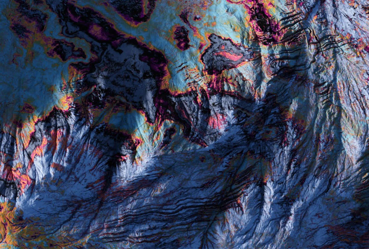 Aerial render of eroded terrain in deep blue and white, crossed by dark gullies and edged with bands of orange and magenta.
