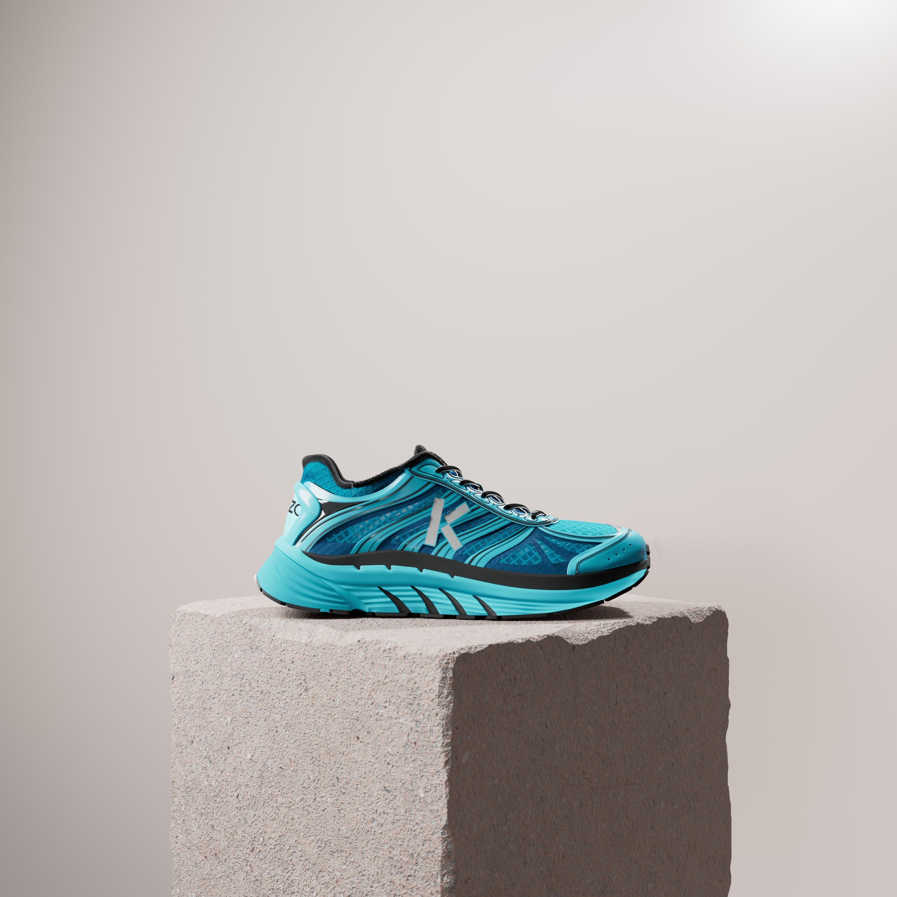 A turquoise running shoe with a white K on a rough stone plinth against a pale beige wall.