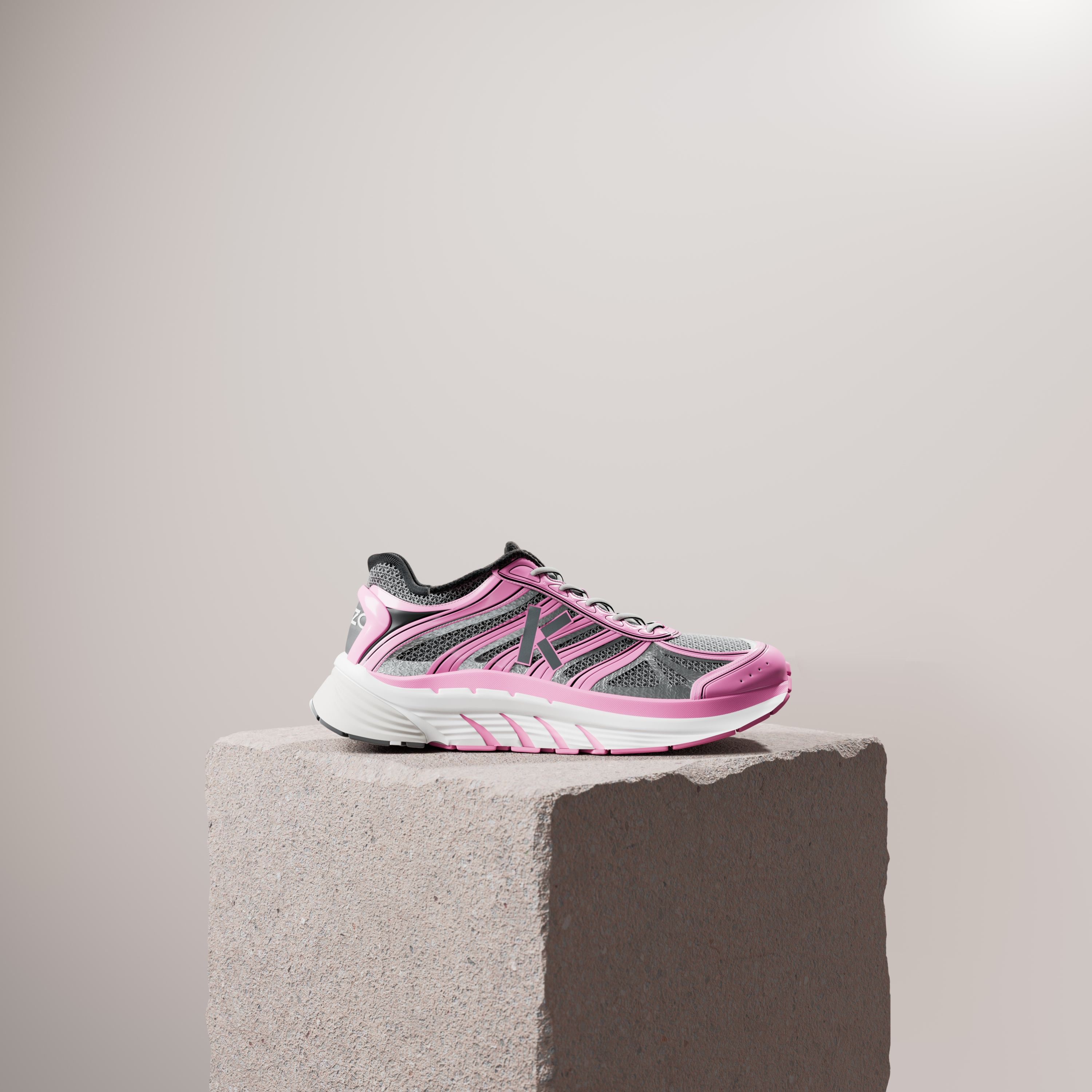 A pink and silver running shoe on a rough stone plinth against a pale beige wall.